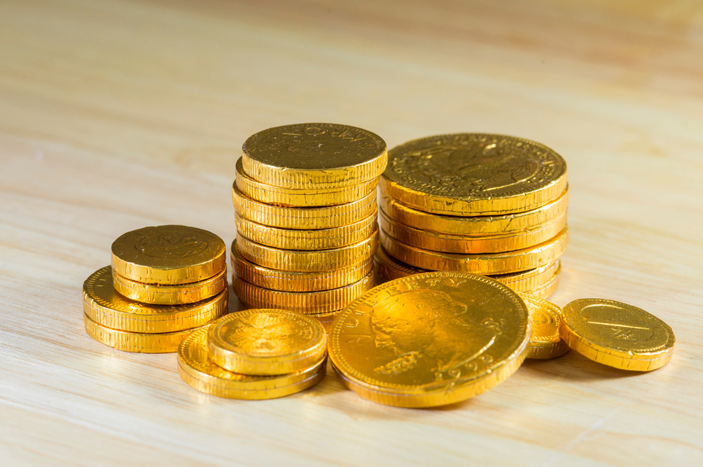 Stacks of bright gold coins on a wooden surface ready for inspection by Coin Buyers in Midland.